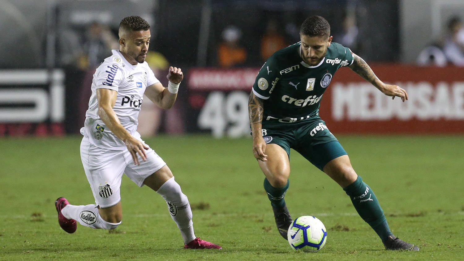 O jogador Zé Rafael, da SE Palmeiras, disputa bola com o jogador Lucas Venuto, do Santos FC, durante partida válida pela vigésima quarta rodada, do Campeonato Brasileiro, Série A, no Estádio da Vila Belmiro. Foto: Divulgação/Sociedade Esportiva Palmeiras