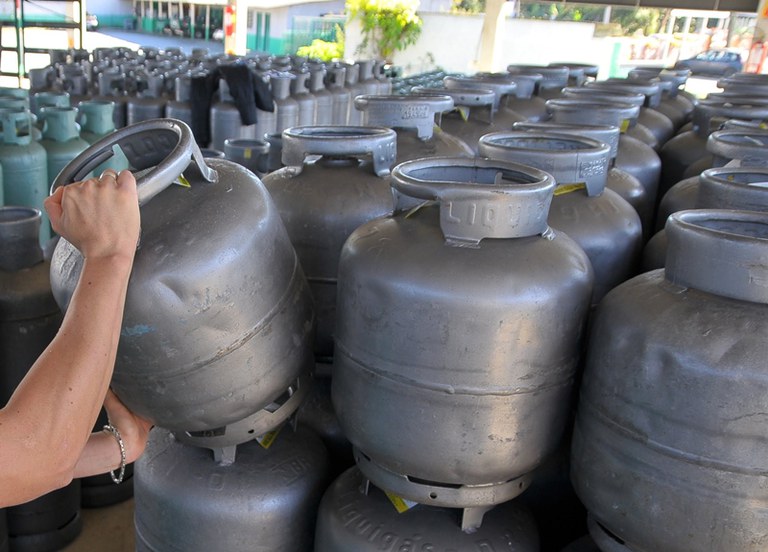 Muitas botijas de gás e uma mão escolhendo uma. Foto: divulgação/Governo Federal