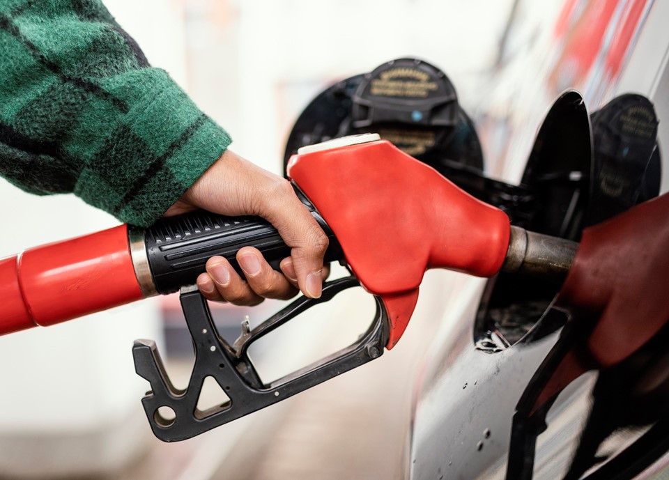 Uma bomba de gasolina abastecendo o tanque de um carro em um posto de combustível