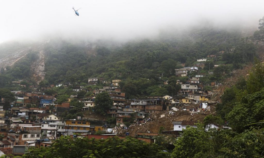 Bombeiros, moradores e voluntários trabalham no local do deslizamento no Morro da Oficina, após a chuva que castigou Petrópolis, na região serrana fluminense. Foto: Tânia Rêgo/Agência Brasil