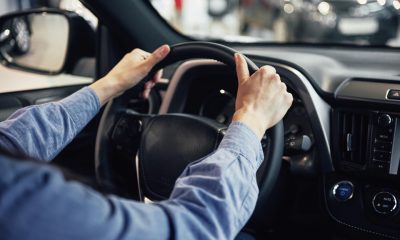 um motorista com as mãos no volante do carro