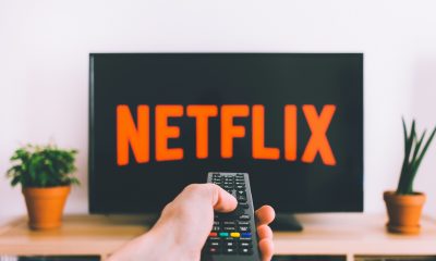 Uma tv ligada na netflix com um controle remoto apontado pra ela