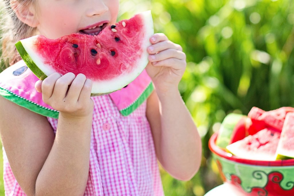 Criança comendo fruta. Foto: Pixabay