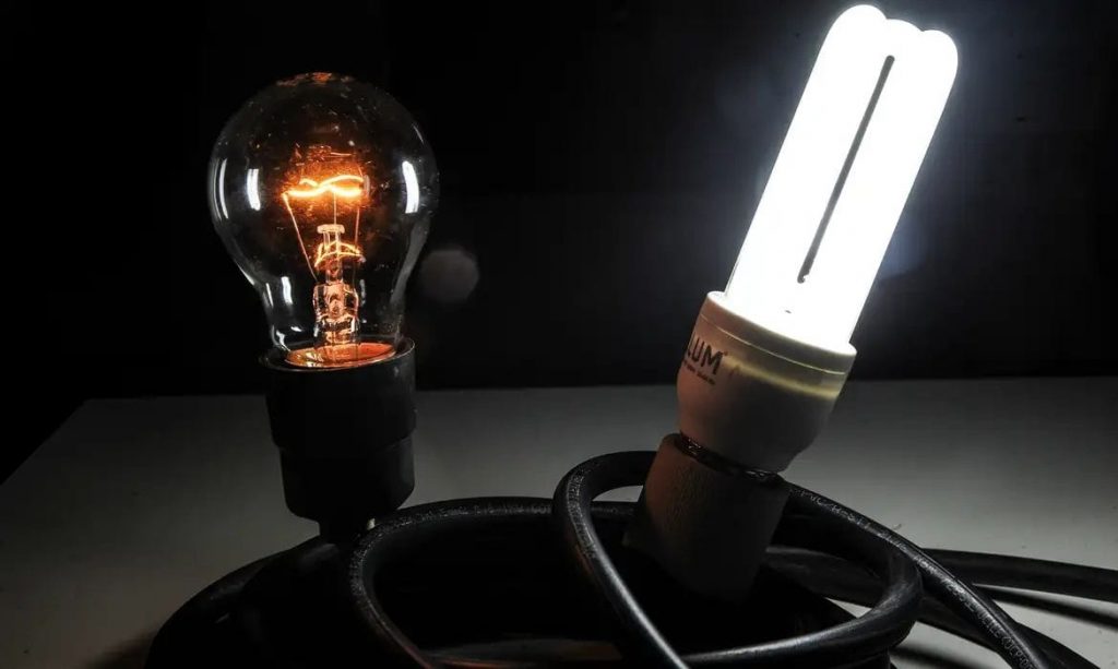 Duas lâmpadas, uma normal e outra fluorescente que mostra sobre eficiência energética.