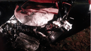 Imagem mostra um automóvel branco destruído após acidente na BR 101
