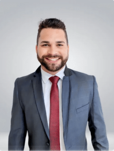 Imagem mostra o vereador Félix Tesch Francisco, de Fundão. Ele está de terno azul, gravata vermelha, camisa branco. É branco, cabelo curto, barba e bigode.