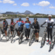 Ciclistas com suas bicicletas posando na nova orla de Cariacica, com o mar ao fundo