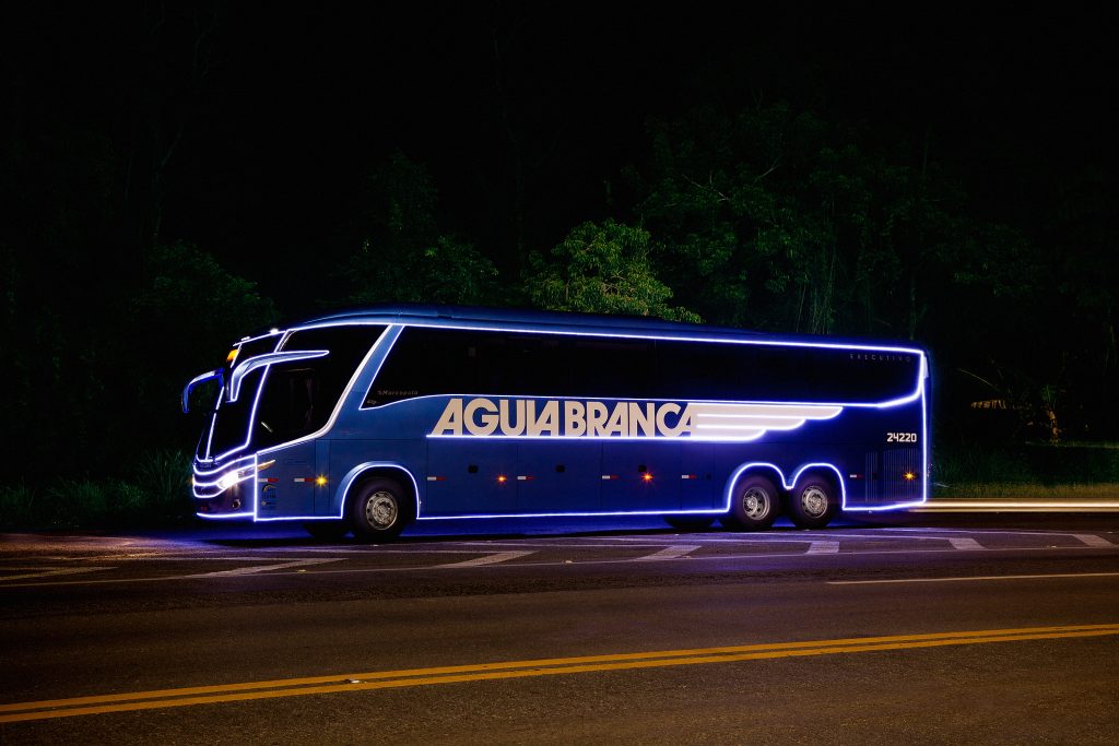 Ônibus da Águia Branca iluminado para o Natal em uma estrada.