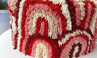 Bolo da Baubo Doceria com a técnica Shag Rug com tons de rosa e vermelho para compor os arco-íris