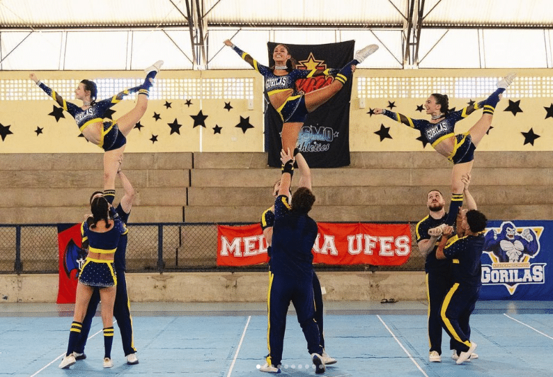 Jovens fazendo acrobacias em evento de Cheerleader