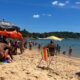 Praia da Costa cheia de banhistas em dia de sol e calor