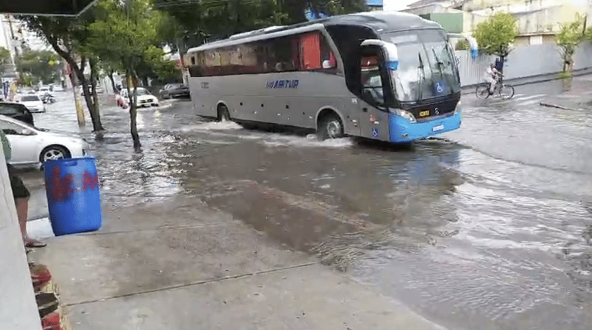 Ônibus passando na avenida Marechal Campos, em Vitória, totalmente alagada após chuva forte