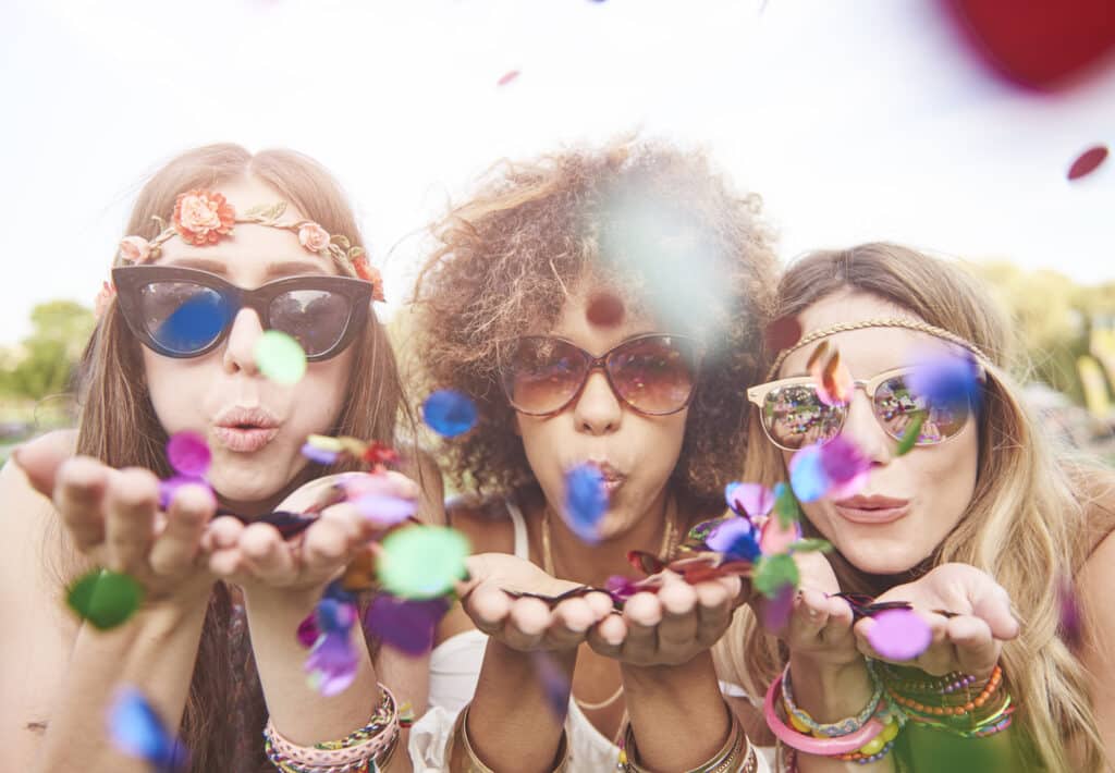 Três mulheres fantasiadas de Carnaval em ritmo de folia para curtir o bloco de rua