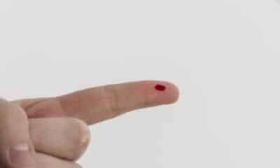 Dedo com uma gota de sangue para exame de dengue na farmácia