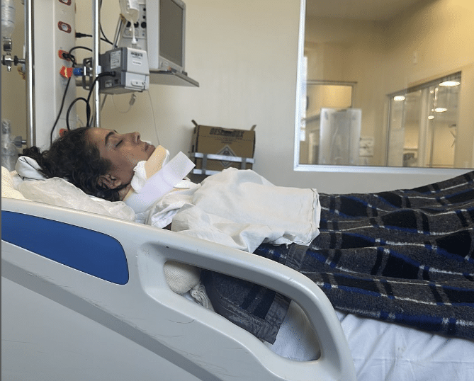 Lindalva Firma deitada em uma cama de hospital na enfermaria. A jovem está paraplégica após lesão durante acidente na Acro-Yoga. 