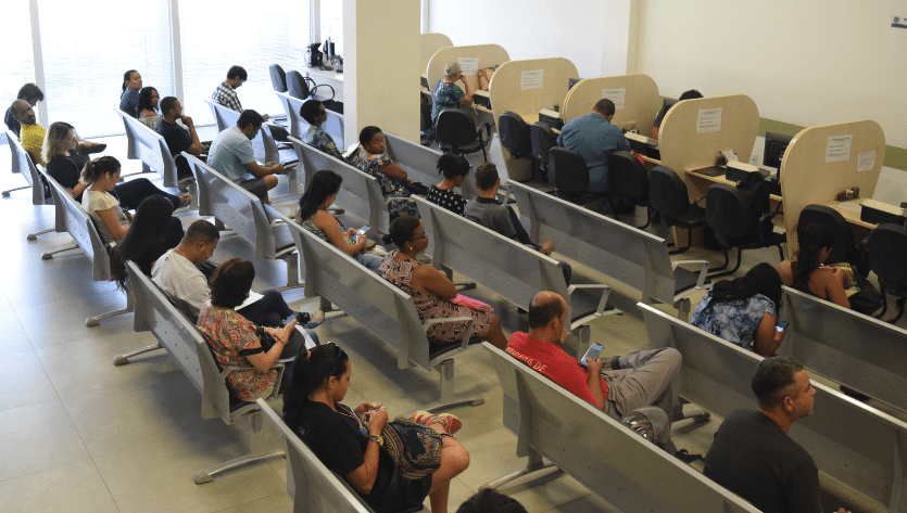Pessoas sentadas em cadeiras à espera de atendimento na Sede da Defensoria Pública do Espírito Santo