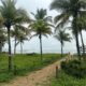 Céu nublado, areia da praia e coqueiros na Praia de Camburi, em Vitória