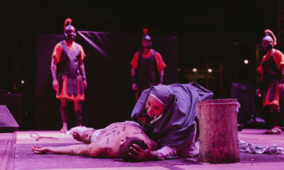 Uma ator representando Jesus Cristo na Paixão de Cristo caído no chão. Maria debruçada sobre ele.