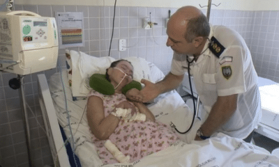 Na foto, Clarinha está deitada na cama do hospital, sendo acompanhada e observada pelo coronel Jorge Potratz