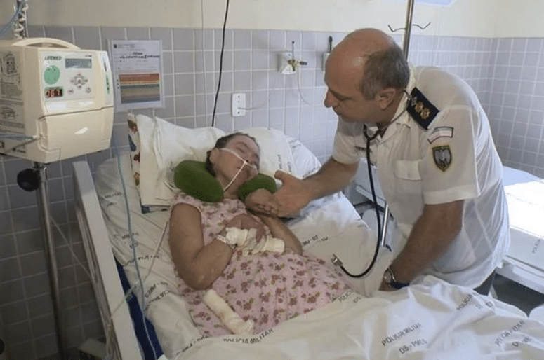 Na foto, Clarinha está deitada na cama do hospital, sendo acompanhada e observada pelo coronel Jorge Potratz