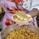 Uma mulher servindo uma porção de arroz de mariscos na Ilha das Caieiras, em Vitória