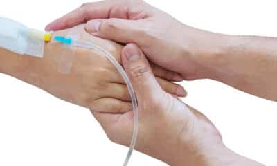 Uma mão de uma profissional aplicando noripurum ev - medicamento endovenoso - em uma paciente