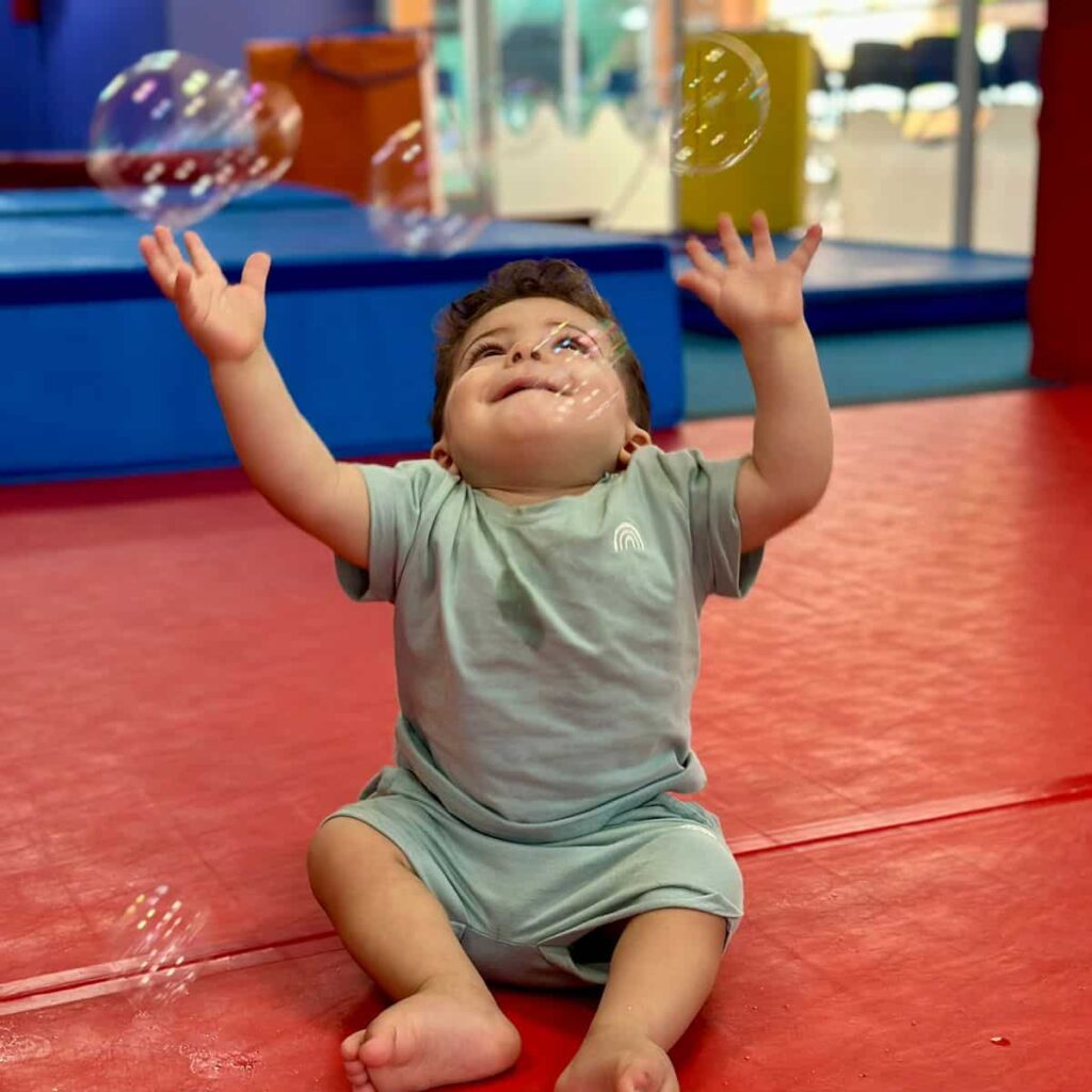 Miguel durante o exercício físico com bolhas de sabão na Little Gym Vitória
