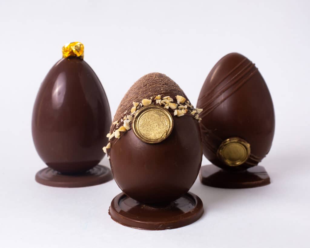 Três ovos de páscoa de chocolate, todos eles são decorados