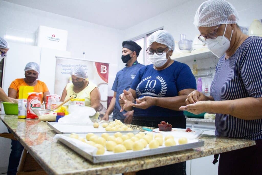 Pacientes com câncer durante um curso de culinária. Com orientação de um chef, elas aprendem a preparar pães