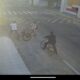 Na foto é possível ver quando um adolescente de bicicleta uniformizado é parado por dois indivíduos que também estão de bicicleta