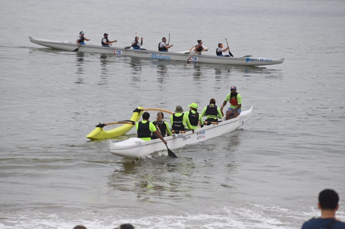 Praticantes de canoa havaiana remando em praia na arena de verão de Vitória