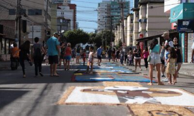 Tapete de Corpus Christi montado em Vila Velha e diversas pessoas contemplando nas ruas