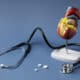 Um estetoscópio e uma reprodução de um coração com comprimidos
