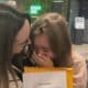 Joice Belisário faz surpresa no Aeroporto de Vitória para filha Maria Eduarda. As duas abraçadas com um papel na mão que indicava o destino da viagem