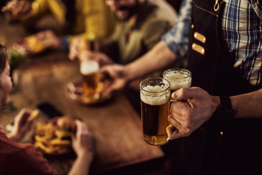 Cervejas sendo servidas em uma mesa de bar para amigos