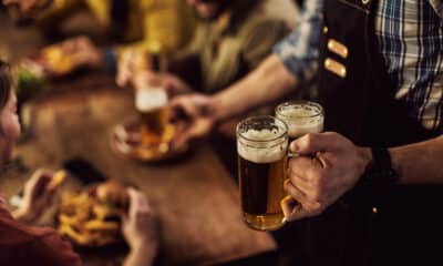 Cervejas sendo servidas em uma mesa de bar para amigos