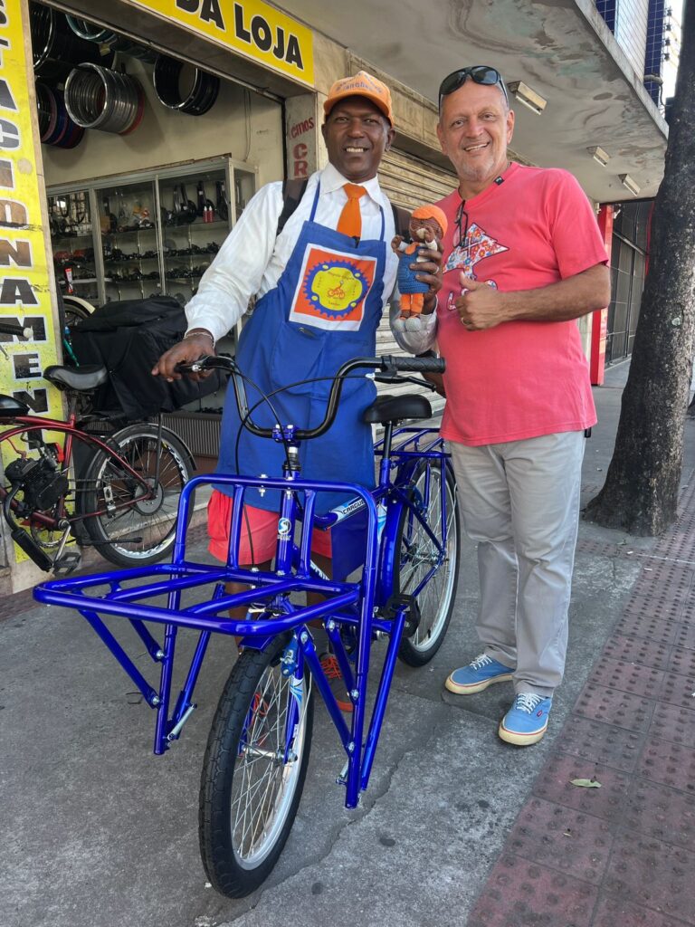 Magrelo com a bicicleta azul nova ao lado do Renato Rocha que fez a doação
