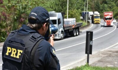 Agente da PRF usando radar móvel para fiscalização de velocidade na rodovia