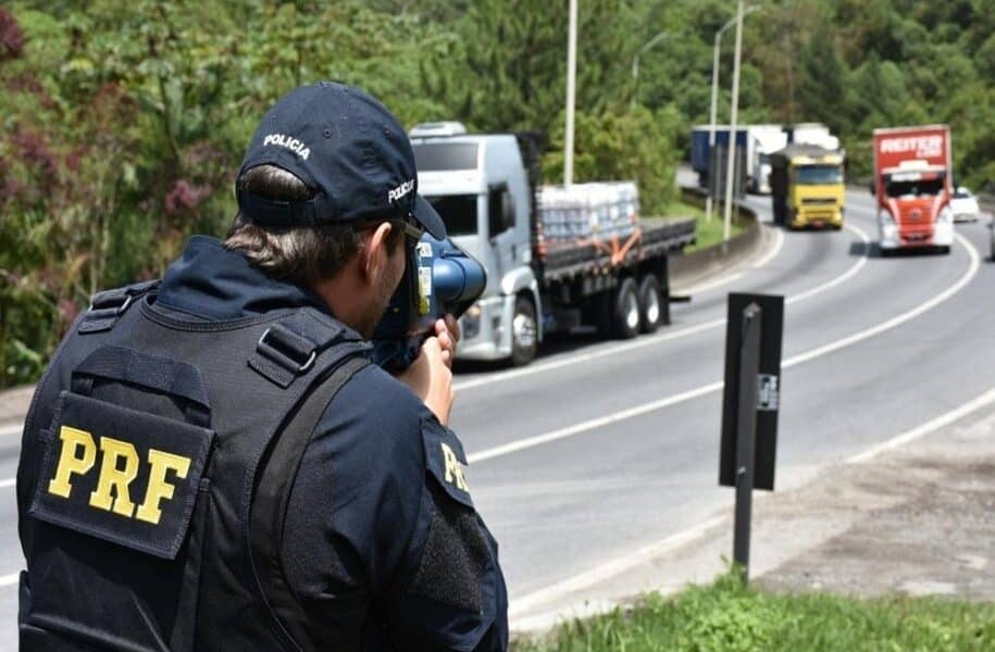 Agente da PRF usando radar móvel para fiscalização de velocidade na rodovia