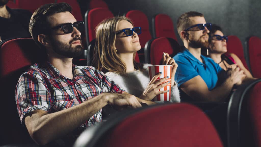 Fãs aguardam ansiosos pelo início dos filmes nos cinemas lotados. Foto: Freepik