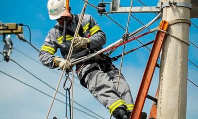 Eletricista da EDP em uma escada fazendo reparo em um poste