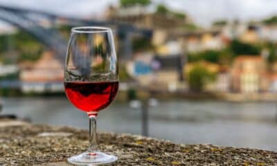 Taça de vinho do Porto e, ao fundo, a cidade que dá nome ao vinho. Foto: Divulgação