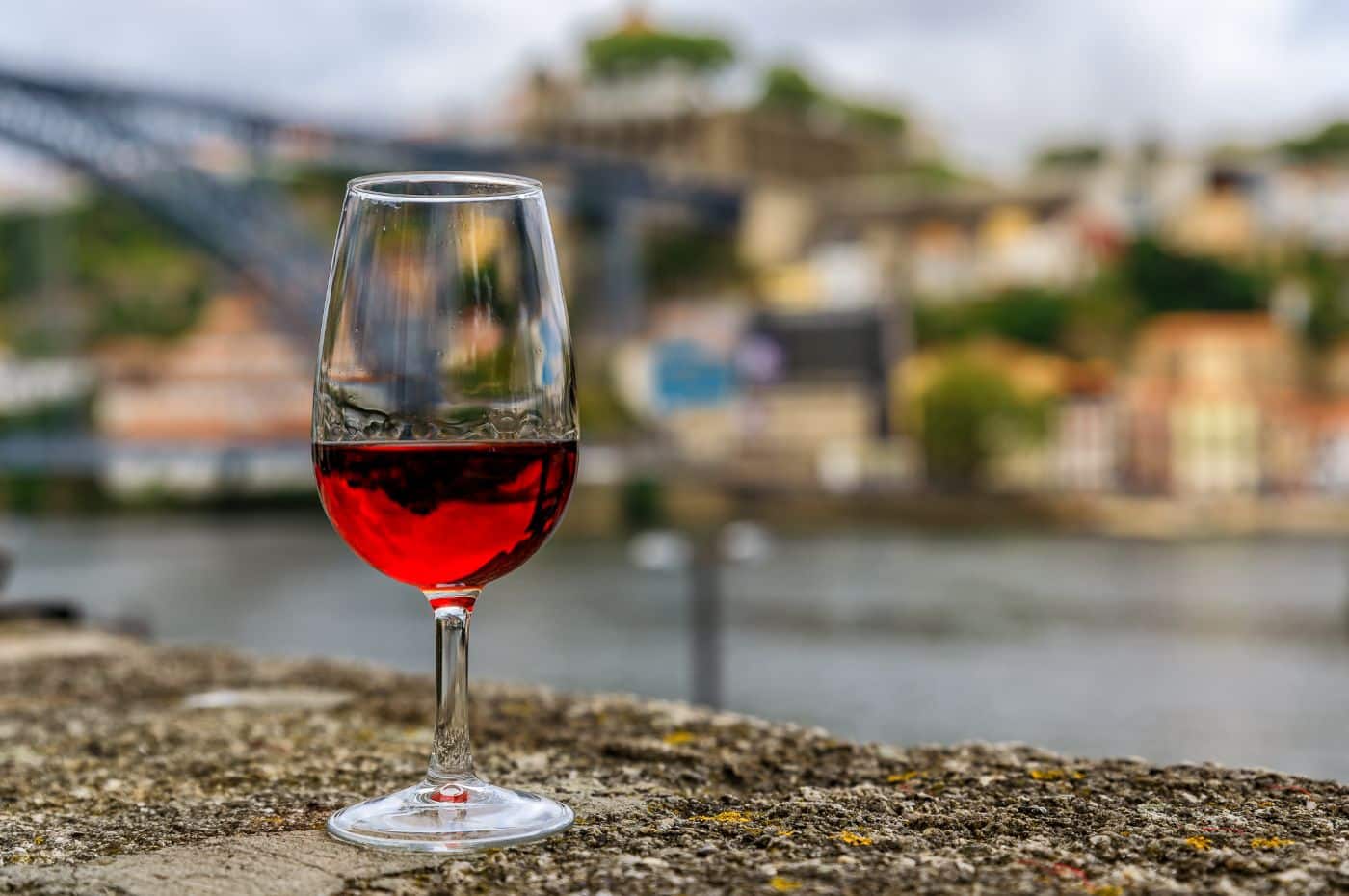 Taça de vinho do Porto e, ao fundo, a cidade que dá nome ao vinho. Foto: Divulgação