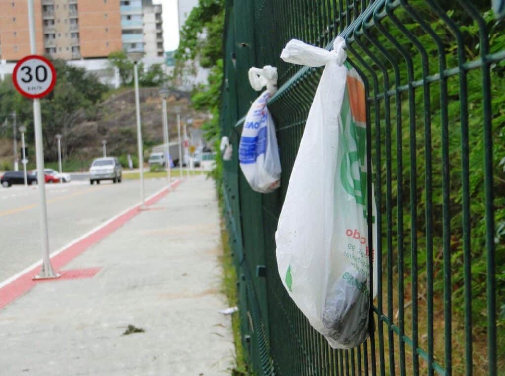 Sacolas com fezes de cachorro são penduradas em grades no Parque das Castanheiras, em Vila Velha