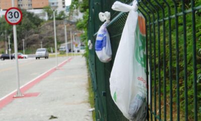 Sacolas com fezes de cachorro são penduradas em grades no Parque das Castanheiras, em Vila Velha