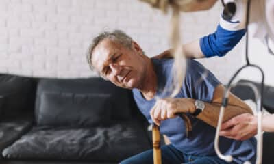 Idosos ajudado por uma profissional da saúde