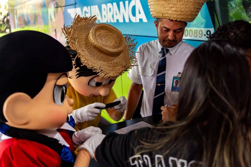 Chico Bento e Rosinha interagindo com os passageiros durante a viagem inaugural