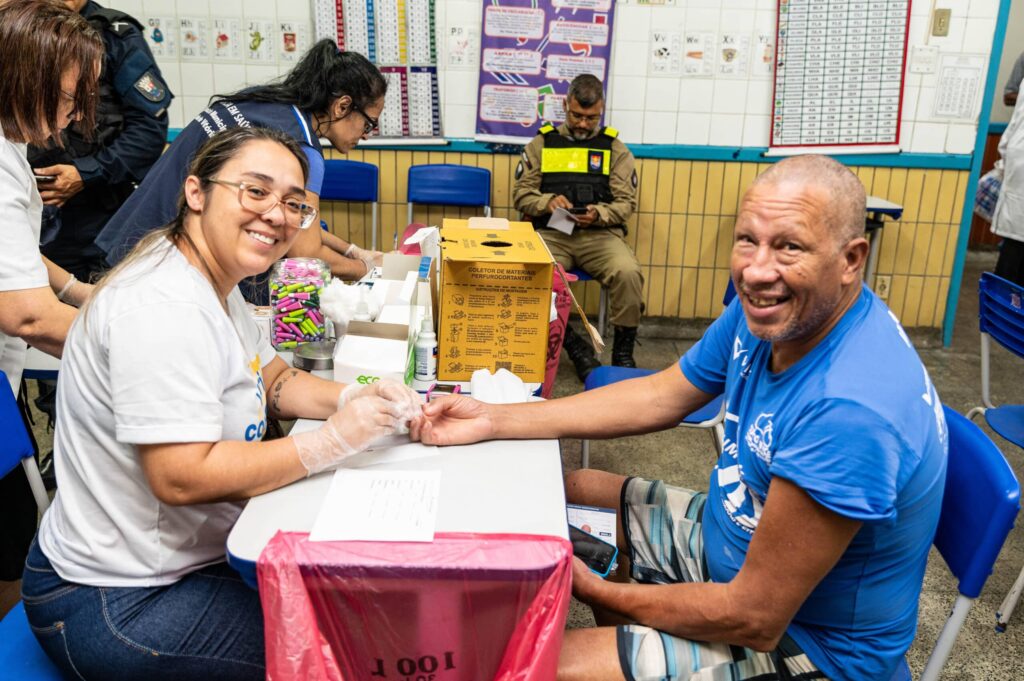 Profissional de saúde realiza teste de glicose durante o mutirão "Vitória com Você"