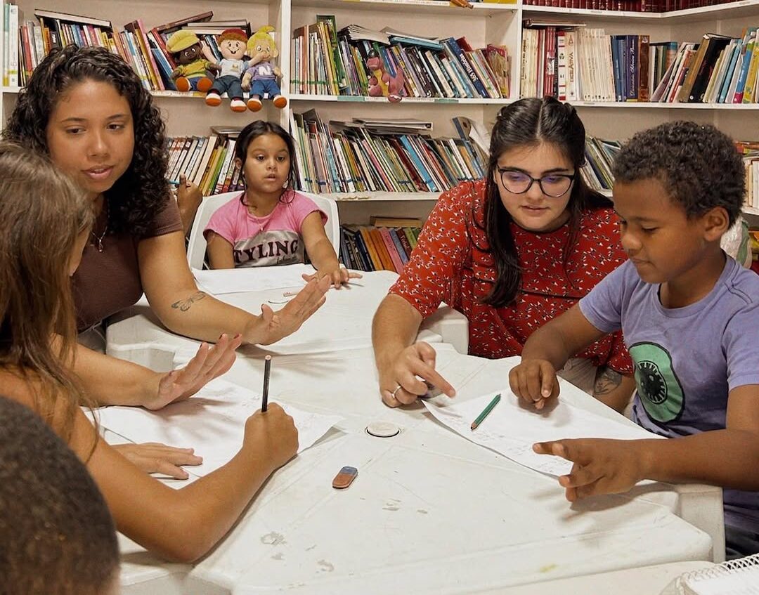 Crianças recebem apoio de voluntários durante as atividades de reforço escolar