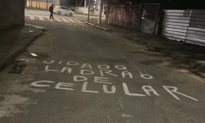 A frase “Cuidado, ladrão de celular” foi escrita no asfalto por moradores para alertar sobre os constantes roubos na região em Vila Velha